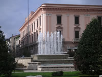 La fontana di Piazza Libertà con alle spalle il Palazzo del Governo