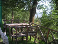 Angolo dedicato al rilassamento, all'ingresso del paese, dove sono state collocate delle panchine in legno a contatto colla fitta vegetazione