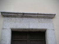 La parte superiore del portale in pietra della Congrega di S. Maria, che contiene un'iscrizione in latino