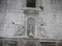 Una statuetta collocata all'interno di un vano sulla parete laterale del campanile della chiesa Madre di Santa Maria delle Grazie