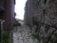 Una stradina del borgo medioevale che rasenta le mura del Castello