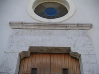 Particolare del portale in pietra della chiesa di S. VIncenzo. Osservando con attenzione, si scorgono due piccoli teschi ai vertici destro e sinistro del portale.