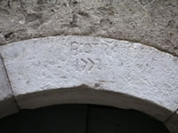 Particolare di un portale in pietra che consente l'accesso ad una cantina. Vi è incisa la scritta: "B:OTRA 1771"