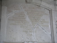 Lapide con iscrizione in latino dietro il portale in pietra della chiesa di Santa Maria del Popolo