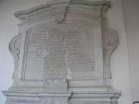 Lapide con iscrizione in latino dietro i portale in pietra della chiesa di Santa Maria del Popolo