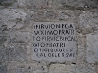 Una scritta che compare su di un blocco di pietra inserito nella facciata della chiesa dei Santi Giovanni e Paolo