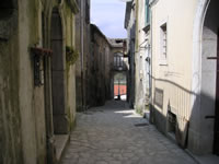 Strada del centro storico, con allo sfondo l'arco del palazzo Di Marzo